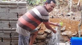 Ilustrasi warga menunjukkan sambungan air minum mengalir deras di sekitar rumahnya. (Foto : Istimewa).