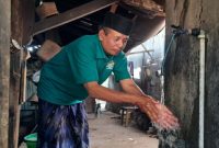 Suryadi, Kades Petungsinarang perlihatkan air jaringan rumah mengalir deras. (Foto : Lintas7.net).