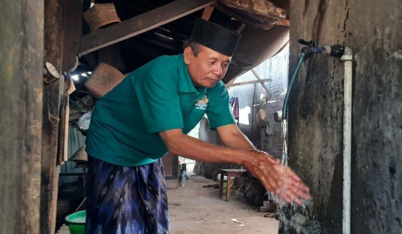 Suryadi, Kades Petungsinarang perlihatkan air jaringan rumah mengalir deras. (Foto : Lintas7.net).