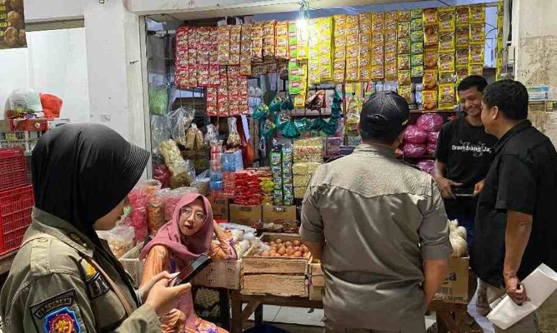 Momen petugas gabungan operasi dan edukasi larangan rokok ilegal kepada pedagang pasar tradisional. (Foto:Istimewa)